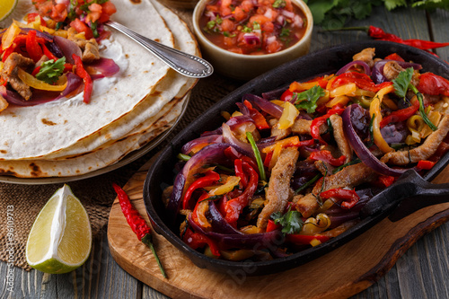 Pork fajitas with onions and colored pepper, served with tortill