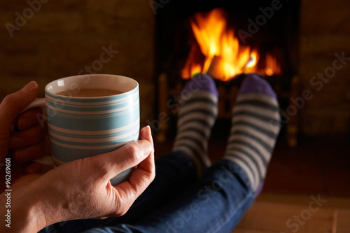 Woman With Hot Drink Relaxing By Fire