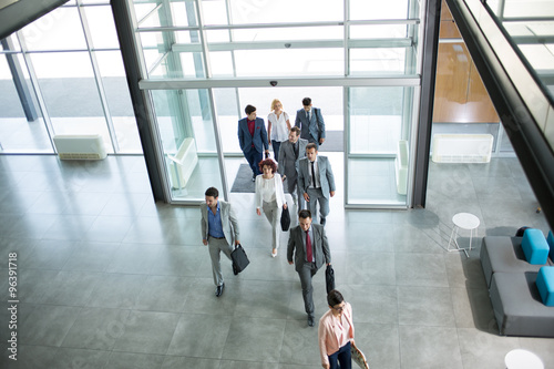  Group of professional business people walking in building.