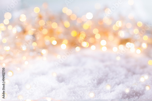 Abstract winter background with snow and golden Bokeh lights