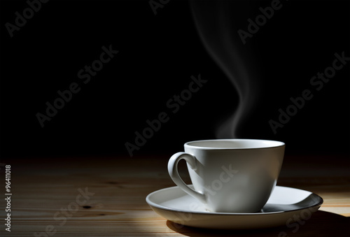 Cup of coffee with smoke on wooden table