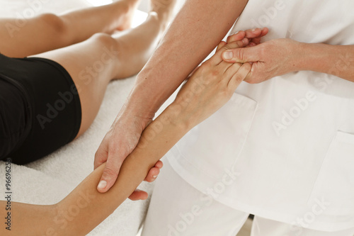 Terapeuta profesional dando masaje en un brazo, en la muñeca y en la mano. Vista supeior y de cerca