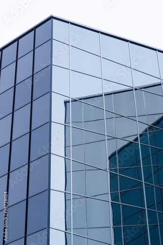 Modern glass and steel building with wall reflections