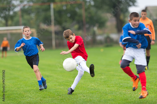 boy kicking football