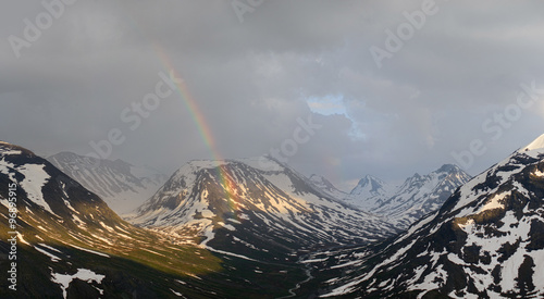 Jotunheimen National Park nature in Norway. Snow mountains with after rain with rainbow.
