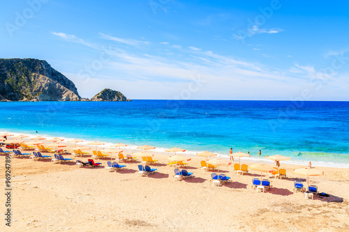 Sunbeds and umbrellas on beautiful Petani beach, Kefalonia island, Greece