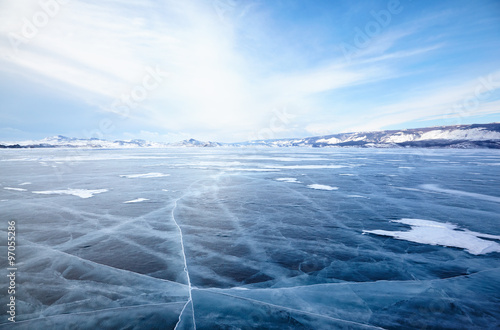 Winter ice landscape on lake Baikal with dramatic weather clouds