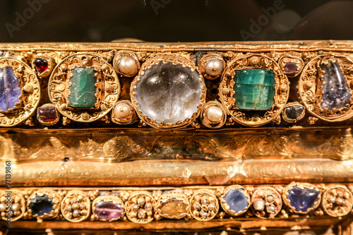 Antique gold jewelry with green and transparent stones.