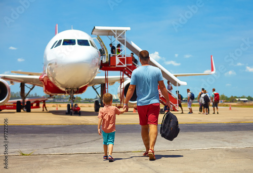 family walking for boarding on plane in airport, summer vacation