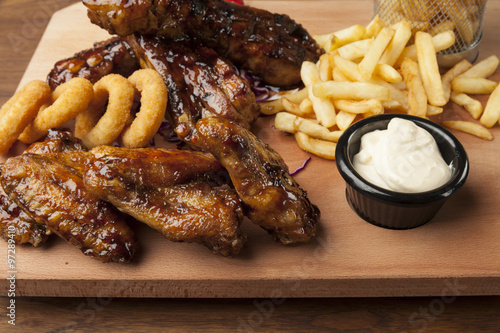meal of chicken wings and ribs with fries