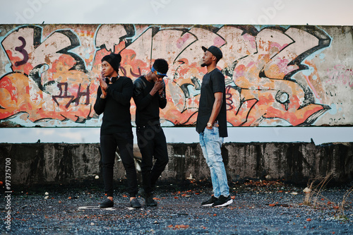 Three rap singers band on the roof background graffiti wall