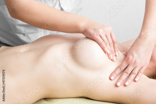 Beauty young woman recieving breast massage at spa. masseur's hands on the woman's breast