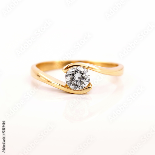 Gold engagement ring with a diamond on a white background