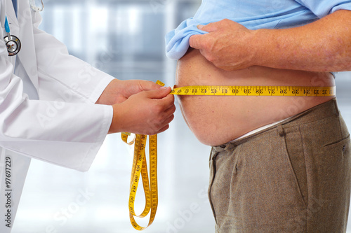 Doctor measuring obese man stomach.