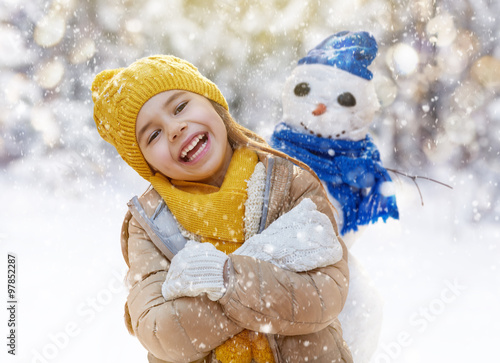 girl playing with a snowman