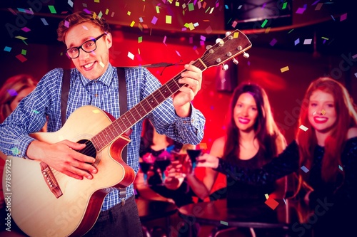 Composite image of geeky hipster playing the guitar 