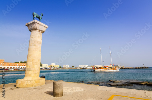 Deer statue with leaving tourist ship in Rhodes harbor