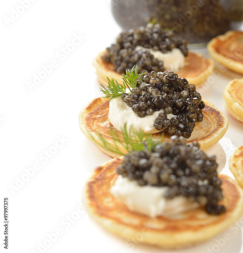 Mini pancakes with black caviar