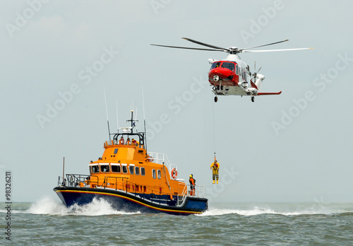 Orange sea rescue boat with rescue helicopter