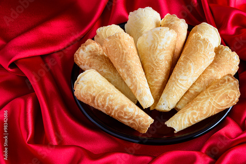 Holiday Krumkake cookies ready to eat on a red serving plate 