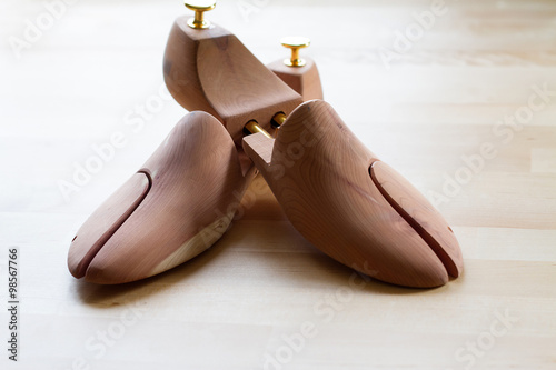 Selective focus of men's wooden shoe stretcher on wooden table