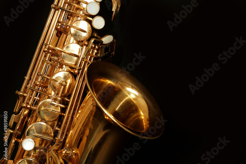 Beautiful golden saxophone on black background, close up