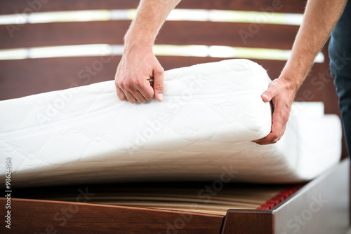 Young man near white bed