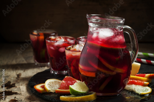 Sangria in pitcher with slices of fruit and ice, selective focus