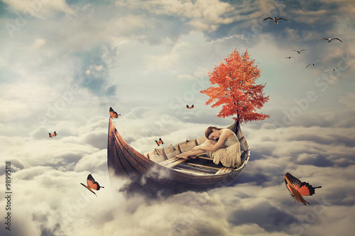 Young lonely beautiful woman drifting on a boat above clouds. Dreamy screensaver