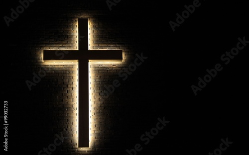 Lighted Cross Background. Back lit cross on a brick background with copy space.