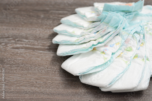 Stack of diapers in bags on a baby bed