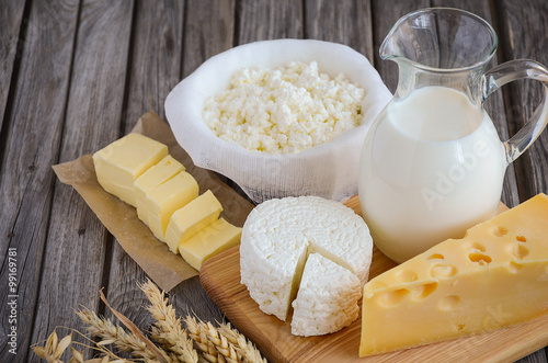 Fresh dairy products. Milk, cheese, butter and cottage cheese with wheat on the rustic wooden background. Horizontal permission. Selective focus.
