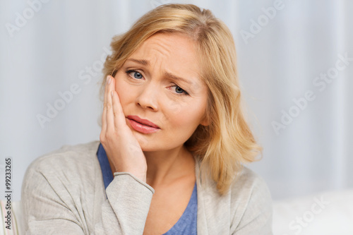 unhappy woman suffering toothache at home