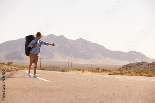 Man On Vacation Hitchhiking Along Country Road