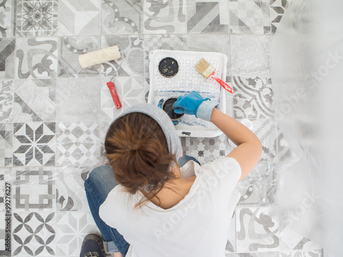 Woman paint wall at home.