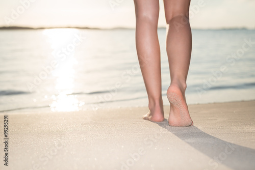 Woman walking on the beach at sunrise enjoying her leisure, Petit Sperone beach, Corsica France