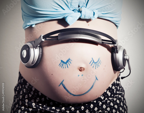 Babybauch mit Gesicht und Kopfhörer