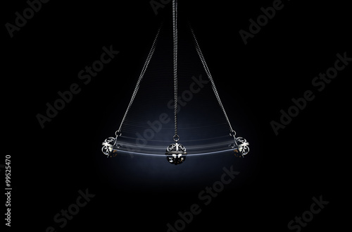 Hypnosis. A silver pendulum swings on a dark background and symbolizes the hypnosis. 