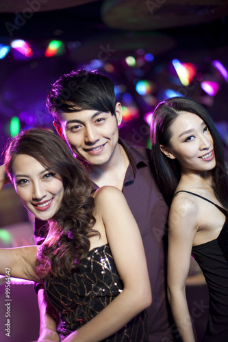Young man surrounding by beautiful women in nightclub