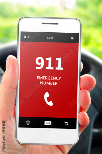 hand holding mobile phone 911 emergency number in car