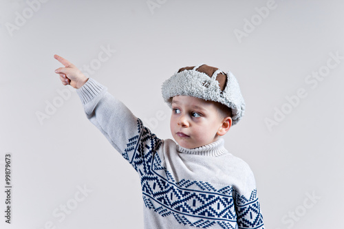 chłopak w zimowej czapce wykonuje gest dłonią 