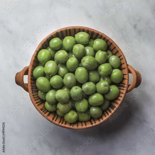 Castelvetrano Green Olives: Bright green Sicilian Olives in brine, in a patterned terracotta bowl