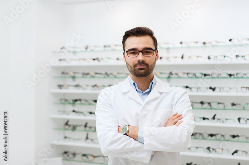 man optician in glasses and coat at optics store