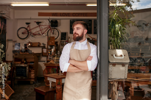 Cafe owner standing in the doorway of his coffee shop