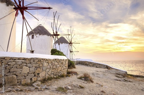 Windmills in Chora,Mykonos,Greece at sunset.Greek whitewashed architecture,a popular landmark,tourist destination on the island of winds,deep blue sky,Aegean sea. Wind mills are now decorative.