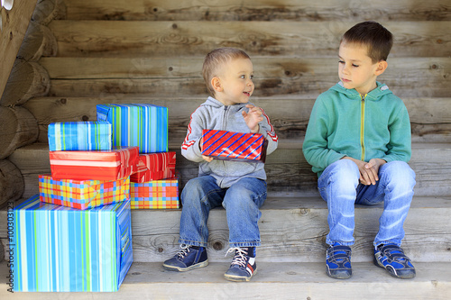 envious child. elder brother is jealous of a pile of gifts that are gifted to younger brother