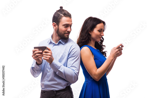 Attractive couple using their smartphones on white background