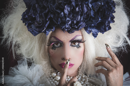 Drag queen with spectacular makeup, glamorous trashy look, posing while using hands and fingers