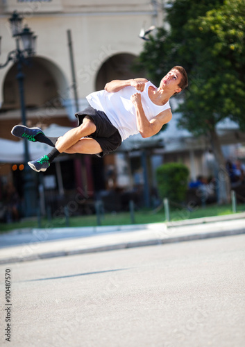 Young man performing somersault in the street