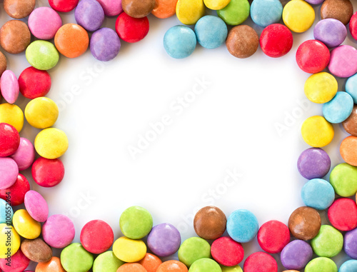 Frame of colorful rounded candies, smarties isolated on white background